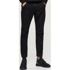 Jeansy SLIM JOGGER - Czarny. Jeansy męskie marki Cropp. Za 119.99 zł.