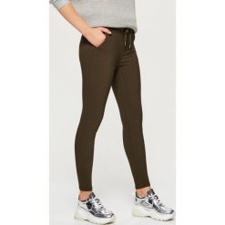Dopasowane spodnie z elastyczną talią - Khaki. Spodnie materiałowe damskie marki Cropp. W wyprzedaży za 39.99 zł.