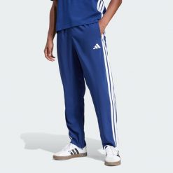 Spodnie Essentials 3-Stripes Stanford Open Hem. Brązowe buty sportowe męskie Adidas, z materiału, bez zapięcia, na fitness i siłownię. Za 179.00 zł.
