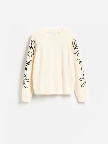 Sweter z ozdobną aplikacją - kremowy. Białe swetry damskie Reserved, l, z aplikacjami, z dzianiny, bez kołnierzyka, bez ramiączek, bez kaptura. Za 139.99 zł.