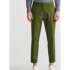 Bawełniane spodnie chino - Zielony. Spodnie materiałowe męskie marki Reserved. W wyprzedaży za 59.99 zł.