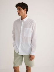 Gładka koszula regular fit - biały. Białe koszule męskie Reserved, l, bez wzorów, z bawełny, bez kołnierzyka, bez ramiączek. W wyprzedaży za 49.99 zł.