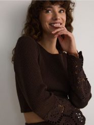 Krótki sweter z ażurowymi rękawami - ciemnobrązowy. Brązowe swetry damskie Reserved, l, w ażurowe wzory, z bawełny, bez kołnierzyka, bez ramiączek, krótkie, bez kaptura. W wyprzedaży za 59.99 zł.