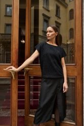 Błyszcząca bluzka z krótkimi rękawami czarna. Czarne bluzki damskie MOODO, l, bez wzorów, z elastanu, bez kołnierzyka, bez ramiączek. Za 99.99 zł.