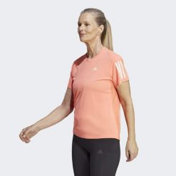 Koszulka do biegania damska Adidas Own the Run Tee. Brązowe koszulki sportowe damskie Adidas, xs, bez wzorów, z materiału, bez kołnierzyka, bez ramiączek, do biegania. W wyprzedaży za 110.75 zł.