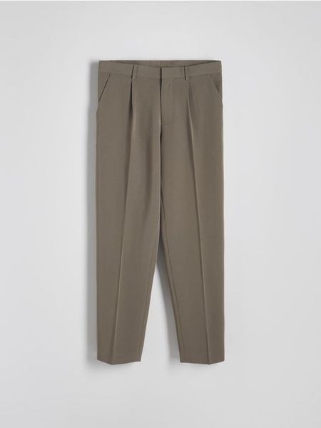 Spodnie comfort fit z kantem - brązowy. Brązowe spodnie materiałowe męskie Reserved, bez wzorów, z tkaniny. W wyprzedaży za 49.99 zł.