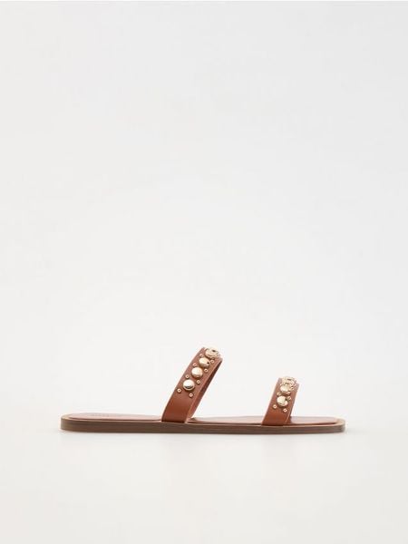 Skórzane klapki z ćwiekami - brązowy. Brązowe klapki damskie Reserved, bez wzorów, ze skóry, bez obcasa. W wyprzedaży za 39.99 zł.