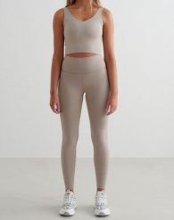 Damskie legginsy wysoki stan, odprowadzające pot, squat proof Sense Tall beżowe. Brązowe legginsy damskie Aim'n, m, bez wzorów, z elastanu, z podwyższonym stanem, na fitness i siłownię. Za 297.00 zł.