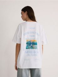 T-shirt oversize z nadrukiem - biały. Białe t-shirty damskie Reserved, l, bez wzorów, z bawełny, bez kołnierzyka. W wyprzedaży za 29.99 zł.