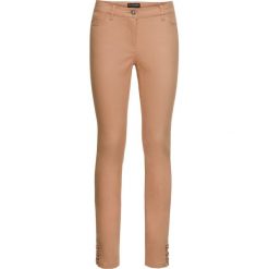 Spodnie SKINNY ze stretchem i sznurowaniem w dole nogawki bonprix kawa lodowa. Spodnie materiałowe damskie marki DOMYOS. Za 49.99 zł.