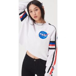 Krótka bluza z motywem NASA - Biały. Białe bluzy damskie Sinsay, l, bez wzorów, bez kaptura. Za 49.99 zł.