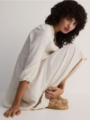 Sukienka oversize z wiskozą i lnem - złamana biel. Sukienki damskie Reserved, l, bez wzorów, z dzianiny, bez kołnierzyka, bez ramiączek, oversize. W wyprzedaży za 89.99 zł.