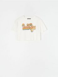 Bawełniana koszulka z nadrukiem The Beach Boys - kremowy. Białe t-shirty damskie Sinsay, l, bez wzorów, z bawełny, bez kołnierzyka. Za 19.99 zł.