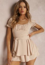 Jasnobeżowy Kombinezon Astinca. Brązowe sukienki damskie Renee, na imprezę, m, bez wzorów, z tkaniny, eleganckie, bez kołnierzyka, bez ramiączek, mini. Za 139.99 zł.