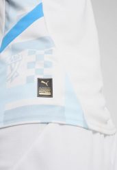 Młodzieżowa koszulka domowa Olympique Marsylia 24/25 PUMA White Bleu Azur Blue. Biała koszulki sportowe męskie Puma, m, w ażurowe wzory, z żakardem, bez kołnierzyka, bez ramiączek, do piłki nożnej. Za 278.50 zł.