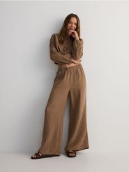 Muślinowe spodnie - brązowy. Brązowe spodnie materiałowe damskie Reserved, l, bez wzorów, z bawełny. W wyprzedaży za 89.99 zł.