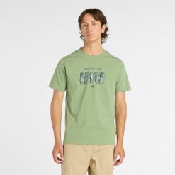 Koszulka męska New Balance MT61778SAAR – zielona. Zielone koszulki sportowe męskie New Balance, l, z aplikacjami, z dresówki, bez kołnierzyka, bez ramiączek. Za 149.99 zł.