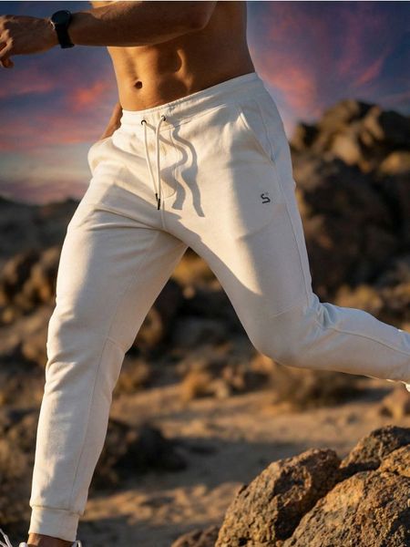 Spodnie tapered fit SNSY PERFORMANCE - biały. Białe spodnie materiałowe męskie Sinsay, l, bez wzorów, na fitness i siłownię. Za 59.99 zł.