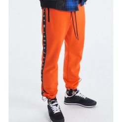 Spodnie joggery kolekcja Night Animals - Pomarańczowy. Spodnie materiałowe męskie marki Cropp. W wyprzedaży za 69.99 zł.