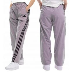 Spodnie damskie adidas Future Icons Three Stripes Woven. Fioletowe obuwie sportowe damskie Adidas, bez wzorów, z poliesteru, na fitness i siłownię. Za 229.99 zł.