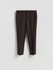 Garniturowe spodnie carrot - ciemnobrązowy. Brązowe eleganckie spodnie męskie Reserved, bez wzorów, z tkaniny. Za 169.99 zł.