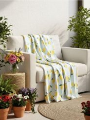 Koc z motywem cytryn - niebieski. Niebieskie kocyki dla dzieci Sinsay. Za 19.99 zł.