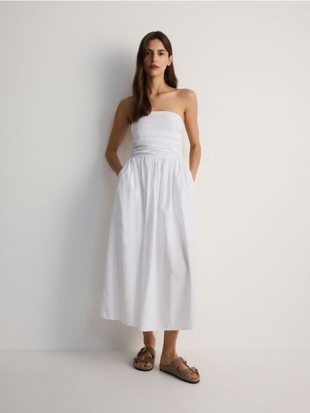 Sukienka z odkrytymi ramionami - biały. Białe sukienki damskie Reserved, l, bez wzorów, z bawełny, bez kołnierzyka, bez ramiączek, midi, z odkrytymi ramionami. W wyprzedaży za 99.99 zł.