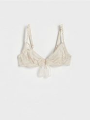 Koronkowy biustonosz z wiązaniem - kremowy. Białe biustonosze Reserved, bez wzorów, z koronki. W wyprzedaży za 25.99 zł.