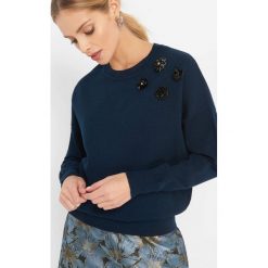Sweter z aplikacją 3D. Niebieskie swetry damskie Orsay, z dzianiny, z okrągłym kołnierzem. Za 99.99 zł.