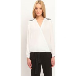 BLUZKA DŁUGI RĘKAW LUŹNA. Białe bluzki damskie TOP SECRET, z aplikacjami, bez kołnierzyka, bez ramiączek. W wyprzedaży za 39.99 zł.