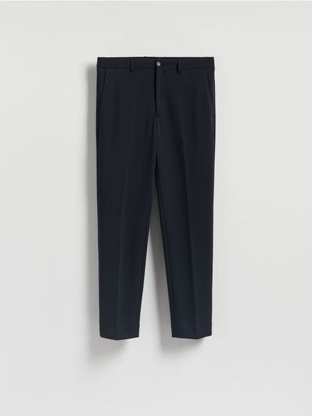 Spodnie garniturowe slim fit - granatowy. Niebieskie eleganckie spodnie męskie Reserved, l, bez wzorów, z bawełny. W wyprzedaży za 99.99 zł.