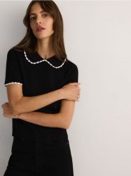 Bluzka z ozdobnym kołnierzem - czarny. Czarne bluzki damskie Reserved, l, bez wzorów, z dzianiny, bez kołnierzyka, bez ramiączek. W wyprzedaży za 49.99 zł.