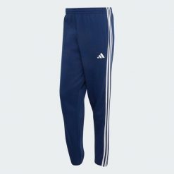 Spodnie Essentials z tkaniny frotté z 3 paskami i zwężanymi nogawkami. Białe spodnie sportowe męskie Adidas, l, bez wzorów, z bawełny. Za 219.00 zł.