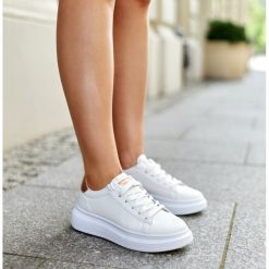 Białe sneakersy na grubej podeszwie Ivalu. Białe trampki i tenisówki damskie bez wzorów, z gumy, eleganckie, bez zapięcia. Za 86.24 zł.