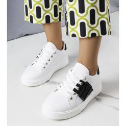 Białe sneakersy zdobione czarną klamerką Erin. Białe trampki i tenisówki damskie z aplikacjami, ze skóry ekologicznej, klasyczne, bez zapięcia. Za 78.89 zł.
