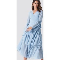 Andrea Hedenstedt x NA-KD Kopertowa sukienka maxi z falbaną - Blue. Sukienki damskie marki Andrea Hedenstedt x NA-KD. W wyprzedaży za 97.18 zł.