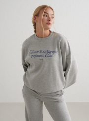 Damska bluza dresowa miękka, luźna, z okrągłym dekoltem Wellness szary melanż. Szare bluzy damskie Aim'n, m, bez wzorów, z bawełny, bez kaptura, na fitness i siłownię. Za 202.80 zł.