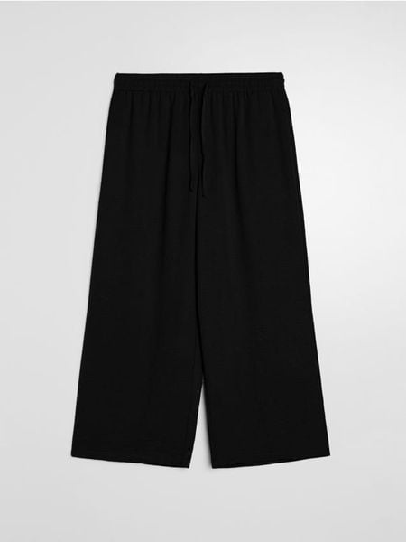 Spodnie culotte z kieszeniami - czarny. Czarne spodnie materiałowe damskie Sinsay, l, bez wzorów. Za 39.99 zł.