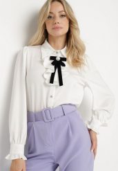 Biała Koszula Satynowa w Stylu Retro z Żabotem i Kokardką Ivelzeda. Białe bluzki damskie Born2be, m, bez wzorów, z bawełny, klasyczne, bez kołnierzyka, bez ramiączek. Za 139.99 zł.