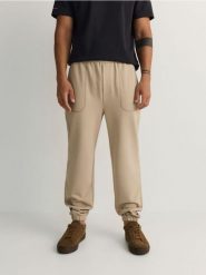 Spodnie jogger regular - beżowy. Brązowe spodnie materiałowe męskie Reserved, l, bez wzorów, z dzianiny. W wyprzedaży za 49.99 zł.