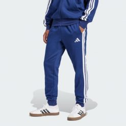 Spodnie Essentials 3-Stripes Fleece. Białe spodnie sportowe męskie Adidas, bez wzorów, z materiału, na fitness i siłownię. Za 171.99 zł.