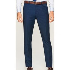 Spodnie garniturowe z tkaniny strukturalnej - Granatowy. Niebieskie eleganckie spodnie męskie Reserved, z tkaniny. Za 149.99 zł.