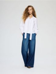 Bawełniana bluzka z wiązaniem - biały. Białe bluzki damskie Reserved, l, bez wzorów, z bawełny, bez kołnierzyka, bez ramiączek. Za 139.99 zł.