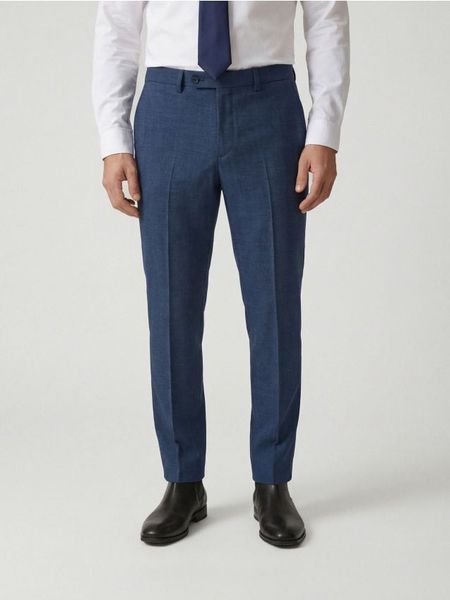 Garniturowe spodnie slim fit - granatowy. Niebieskie eleganckie spodnie męskie Reserved, l, bez wzorów, z tkaniny. Za 169.99 zł.