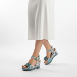 Sandały damskie Laura Vita, ze skóry naturalnej z kwiatowym nadrukiem i ozdobną aplikacją na pasku z przodu, niebieskie, 75 AC1198-75. Niebieskie klapki damskie Laura Vita, z aplikacjami, ze skóry, bez obcasa, na koturnie. Za 349.00 zł.