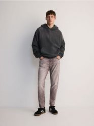 Jeansy carrot slim - mahoniowy. Brązowe jeansy męskie Reserved. W wyprzedaży za 49.99 zł.