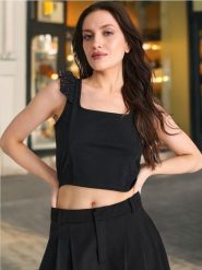 Bluzka na ramiączkach z ażurowymi falbankami - czarny. Czarne bluzki damskie Sinsay, l, w ażurowe wzory, z materiału, bez kołnierzyka, bez ramiączek. W wyprzedaży za 17.99 zł.