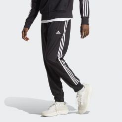 Spodnie dresowe męskie adidas AEROREADY Essentials Tapered Cuff Woven 3-Stripes. Białe spodnie sportowe męskie Adidas, m, bez wzorów, z dresówki, na fitness i siłownię. Za 229.00 zł.