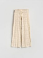 Ażurowe spodnie z bawełną - kremowy. Białe spodnie materiałowe damskie Reserved, l, w ażurowe wzory, z bawełny. Za 139.99 zł.