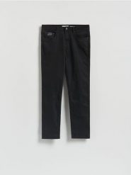 Spodnie Slim fit - czarny. Czarne spodnie materiałowe męskie Reserved, bez wzorów, z bawełny. W wyprzedaży za 99.99 zł.